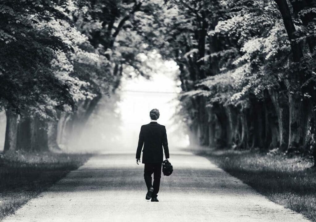 Man walking down tree lined road